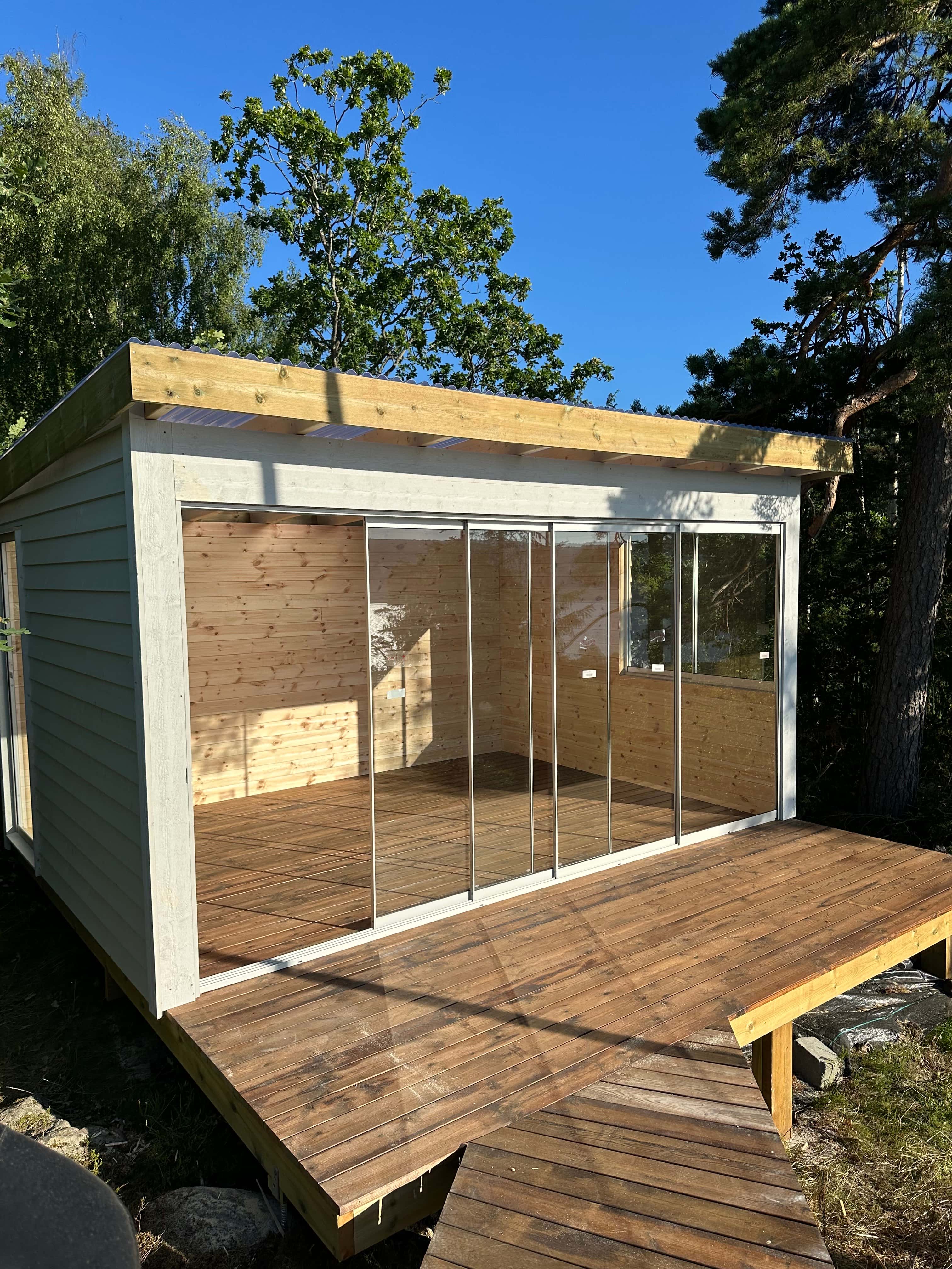 Deck framing around a hot tub with ocean view and wooden fence in the background